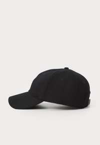 Cappellino da baseball nero realizzato in tessuto morbido e testurizzato. Presenta una visiera curvata, dettagli cuciti e una cinturino con un accento metallico sul retro.