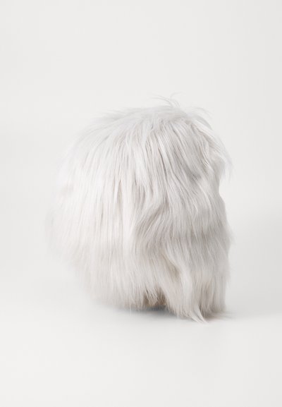 Valge kunstkarusnahast puf, millel on ümar kuju. Pikkad, pehmed kiud loovad karvase tekstuuri. Ei ole nähtavaid mustreid ega riistvara. Lihtne ja minimalistik disain.