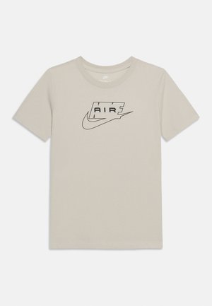 Beige short-sleeve T-shirt with black Nike Air logo and swoosh centered on the chest, crew neck, plain background.