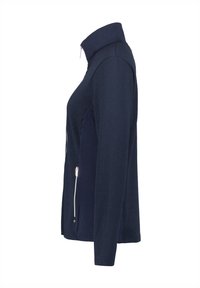 Veste zippée navy en tissu texturé, avec un col haut et une fermeture éclair sur le côté. Le matériau semble lisse avec un design structuré.