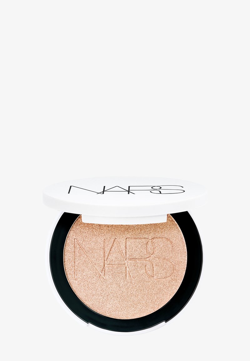Illuminante NARS in una confezione rotonda. Presenta una polvere scintillante color oro rosa con il logo impresso sulla superficie, racchiuso in un coperchio bianco.