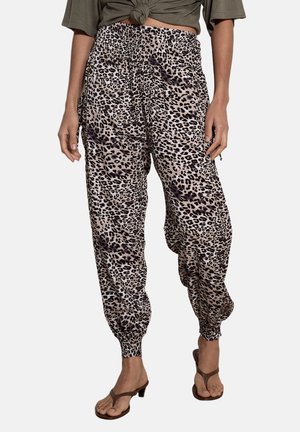 Locker sitzende Leopardenmuster-Hose mit elastischem Bund und Bündchen, getragen mit braunen Sandaletten mit Absatz und einem geknoteten olivgrünen Top.