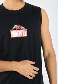 Must have riide, mustaga ilma varrukat särk, mis on valmistatud puuvillast, esipanelil on värviline Spider-Man graafika punase "MARVEL" logoga.