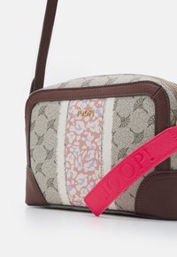 Borsa strutturata con una combinazione di tessuto beige, rifiniture floreali rosa e profili in pelle marrone. Presenta un ampio manico rosa brillante e un logo distintivo.