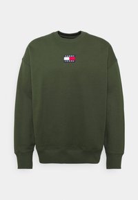 Tmavě zelená mikina s kulatým výstřihem, s žebrovanými manžetami a lemem, s malou obdélníkovou nášivkou loga Tommy Jeans na hrudi.