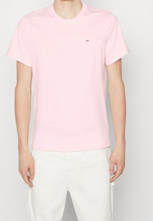 Světle růžové bavlněné tričko s kulatým výstřihem a krátkými rukávy. Má malou značkovou nášivku na levé straně hrudi.