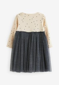 Robe à manches longues avec un haut beige à côtes orné de pois noirs et une jupe en tulle bleu marine décorée de paillettes dorées. Taille élastique.