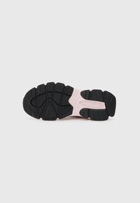 Athletic shoe sole featuring a textured black rubber tread with pink accents, showing a layered design and distinct tread pattern.