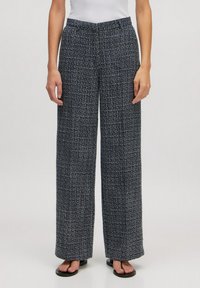 Navy en witte geruite wijde broek, gemaakt van een textuurstof. Voorzien van een middelhoge tailleband en zijzakken.