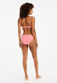 Bikini rosa con una texture a coste e spalline regolabili. Il top ha una chiusura a gancio, mentre il costume ha un design a vita alta con linee sottili.