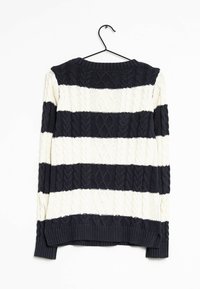 Gebreide trui met marineblauwe en crèmekleurige horizontale strepen, voorzien van een gestructureerd kabelpatroon en een geribde zoom. Hangt aan een zwarte haak.