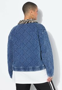 Kurtka z dżinsu pikowana, z kołnierzem w panterkę, w niebieskich odcieniach, z elastycznym dołem i ściągaczami na rękawach; teksturowana powierzchnia z wzorem diamentowym.