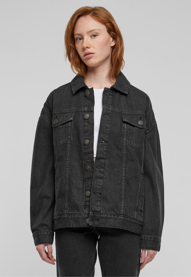 Zwarte denimjas met een kraaghalslijn, sluiting met knopen aan de voorkant, twee borstzakken en verlaagde schouders voor een ontspannen pasvorm.