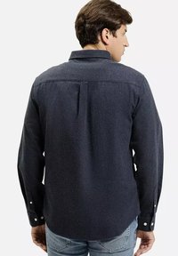 Ciemnoniebieska koszula z długim rękawem, wykonana z teksturowanej tkaniny, z kołnierzykiem zapinanym na guziki, plisą z tyłu i zapinanymi mankietami.