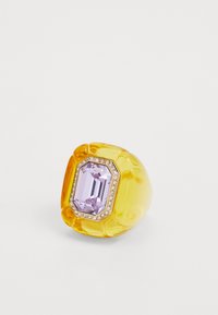 Yellow acrylic ring with a large rectangular lilac stone, encircled by a row of small clear gems. Smooth, polished finish.