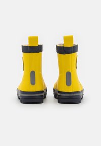 Bottes en caoutchouc jaunes avec une finition texturée, des accents gris et des languettes de traction en haut ; conçues pour un usage résistante à l'eau.