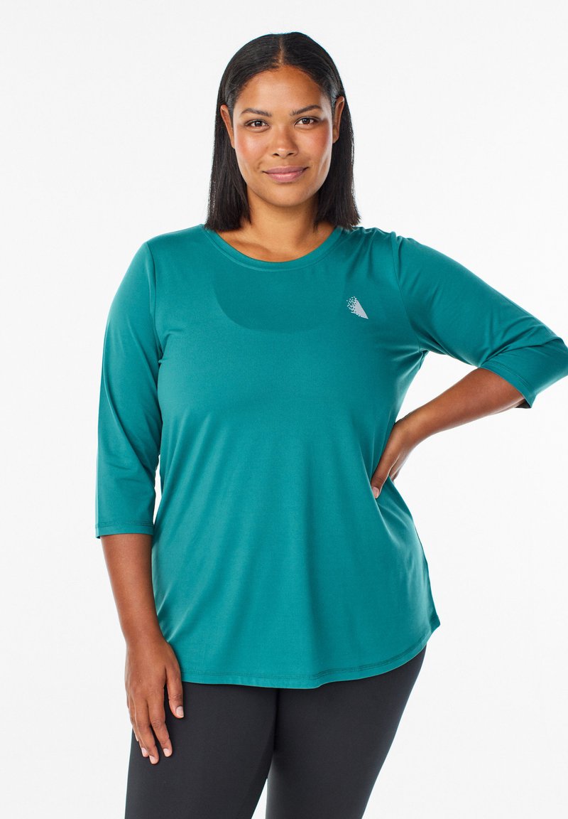 Tyrkysový top s dlhým rukávom, okrúhlym výstrihom a rukávmi po trištvrte. Vyrobený z hladkej, elastickej látky. Obsahuje malé, nenápadné logo na hrudi.