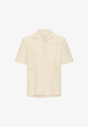 Kortermet skjorte i lys krem med diamantmønstret tekstur, med krage og brystlomme. Knappestol foran.