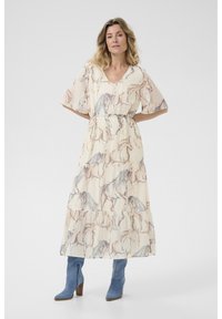 Krém színű maxi ruha ló mintával, rövid ujjakkal, V-kivágással és réteges kivitelben. Kék bokacsizmával párosítva.