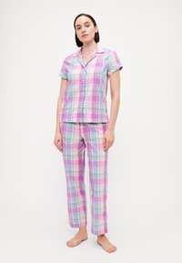 Σετ πιτζάμας από βαμβάκι με καρό σχέδιο που περιλαμβάνει κοντομάνικο μπλουζάκι μ�ε κουμπιά, τσέπη και μακριά παντελόνια σε παστέλ απόχρωσεις ροζ, μπλε και λεβάντα.