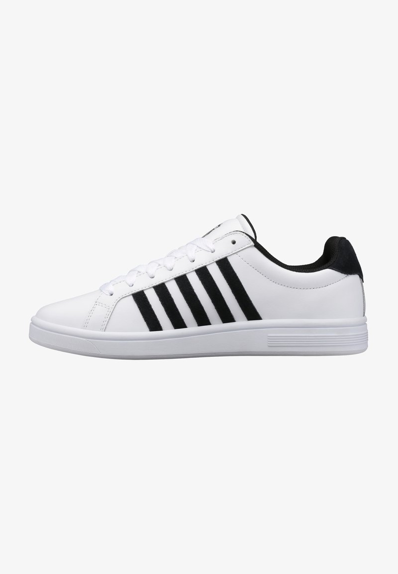 White athletic sneaker with black suede accents and three black stripes on the side. Features a smooth leather upper and white rubber sole.