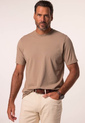 Beige T-Shirt mit kurzen Ärmeln, aus Baumwollstoff, Rundhalsausschnitt, kombiniert mit cremefarbenen Hosen und einem braunen Ledergürtel, ergänzt durch eine Uhr.