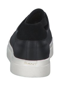 Black leather sneaker with a low profile, sueded back, and white rubber sole. Features gold logo on the side and elastic heel tab for easy wear.