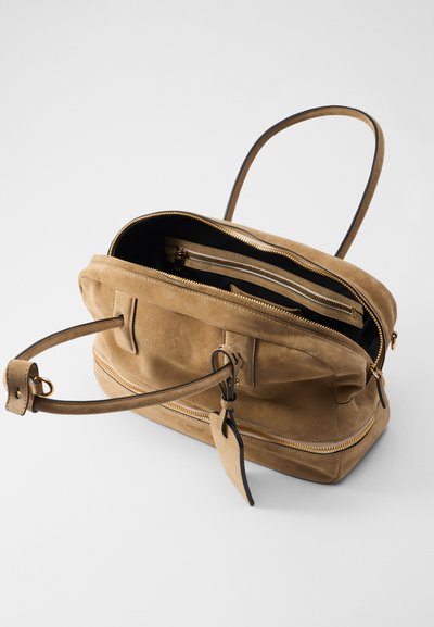 Brązowa torebka z zamszu z zamykaną główną komorą, dwoma wewnętrznymi kieszeniami i pojedynczym uchwytem. Posiada złote okucia oraz fakturowane wykończenie.