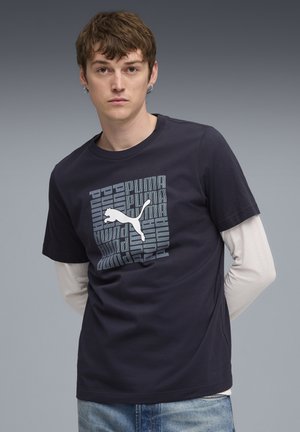 Marineblå bomulds T-shirt med et centralt gråt Puma-logo grafik med tekst. Rund hals, korte ærmer og afslappet pasform.