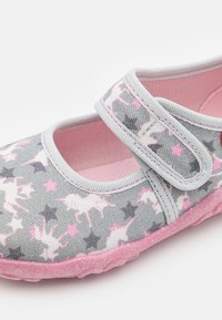 Sapatilha de tecido cinza com um padrão de unicórnio rosa e estrelas, apresentando uma tira de fecho fácil, interior rosa e sola texturizada rosa.
