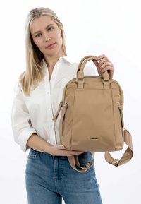 Zaino in nylon beige con doppio manico corto, tracolla regolabile, due tasche con zip e dettagli in metallo argentato.