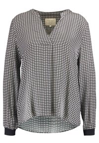 Blouse noire et blanche à manches longues avec un motif floral, décolleté en V et poignets élastiques. Tissu léger avec une coupe décontractée et un ourlet arrondi.