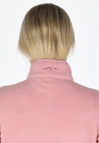 Giacca in fleece rosa con colletto alto e un discreto logo di montagna sul retro. Texture liscia con dettagli cuciti.