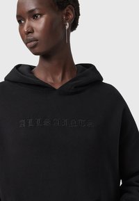 Felpa nera con cappuccio caratterizzata da un ricamo tono su tono con la scritta "ALLSAINTS". Tessuto morbido, vestibilità comoda e design classico con tasca a marsupio.