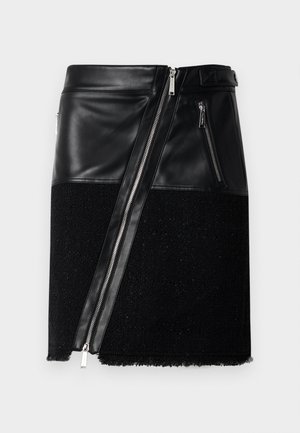 Gonna nera che combina pelle e tessuto strutturato. Presenta una cerniera diagonale, due tasche laterali con zip e un orlo sfrangiato nella parte inferiore.