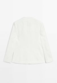 Blazer bianco a maniche lunghe con una leggera svasatura ai fianchi, mostrato piatto in vista posteriore su uno sfondo bianco.