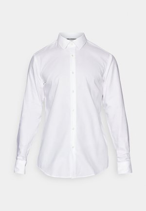 Hvid skjorte med klassisk krave, lange ærmer og lige kant. Lavet af glat stof med synlige sømme og knapper.
