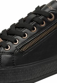 Sneaker in pelle nera con suola in gomma testurizzata, dotato di occhielli in bronzo e un dettaglio con zip sul lato. I lacci sono neri e piatti.