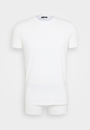 T-shirt de manga curta branca e calções a condizer com um padrão texturizado de texto repetido. Tecido suave com um design de gola redonda.