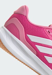 Bott chaussure de sport rose avec dessus en maille, accents texturés et rayures blanches. Comprend une semelle en caoutchouc, un col rembourré et un design flexible.