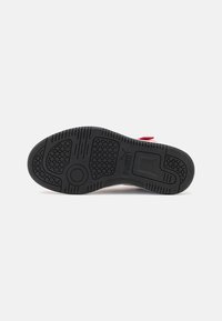 Semelle en caoutchouc noir avec motifs de grip texturés, présentant un grip central circulaire et un design moulé pour une adhérence et une stabilité.