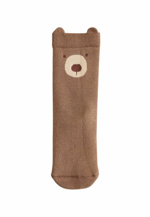 Brun socka med björndesign; har rundade öron, krämfärgad nos och ansiktsdetaljer. Mjuk stickad textur; utformad för komfort.