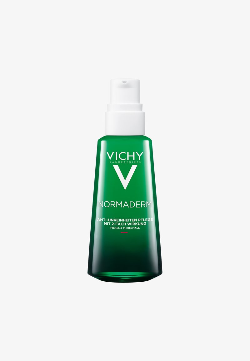 Grüne Glasflasche mit einem weißen Pumpenspender; das Etikett zeigt das "Vichy"-Logo und den Produktnamen "Normaderm" mit Text in deutscher Sprache.