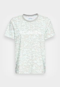 Kortärmad t-shirt i ljusblått med ett fläckigt grått mönster. Har rundad halsringning och en stor vit "Columbia"-logotyp på framsidan.