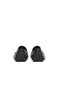 Crne kožne cipele na slip-on s teksturiranim završetkom i kvadratnim gumenim petom. Zaobljen prst i minimalni detalji šivanja sa strane.