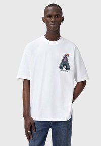 Hvid bomulds T-shirt med korte ærmer, der har et grafisk design på venstre bryst. Designet inkluderer en hånd, en rose og teksten "ALLSAINTS".