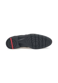 Semelle de sneaker noire en caoutchouc texturé, avec une bande d'accent rouge. Des motifs circulaires et des rainures offrent une adhérence. Matériau durable.