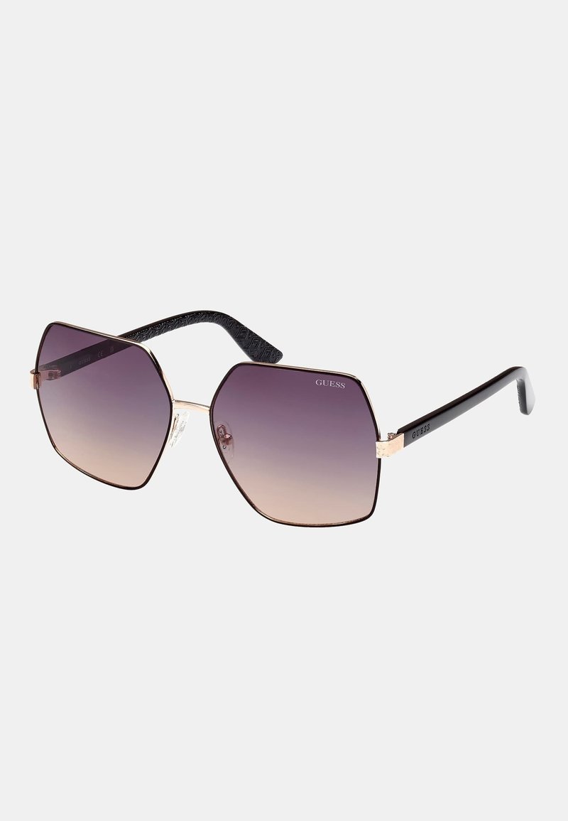 Ochelari de soare hexagonali cu lentile violet în degradé, ramă din metal aurie și brațe din plastic negru texturat cu un model subtil.