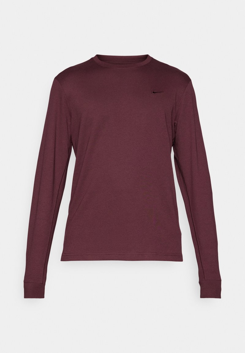Długi rękaw burgundowy t-shirt z okrągłym dekoltem, z małym czarnym logo Nike po lewej stronie na klatce piersiowej, prezentowany na białym tle.