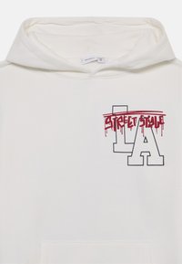 Felpa bianca con cappuccio caratterizzata da una grafica frontale con "STREET STYLE" in un font rosso che sembra colare e la scritta "LA" in grandi lettere nere contornate accanto ad essa.